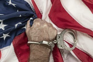 Convict grasping American Flag